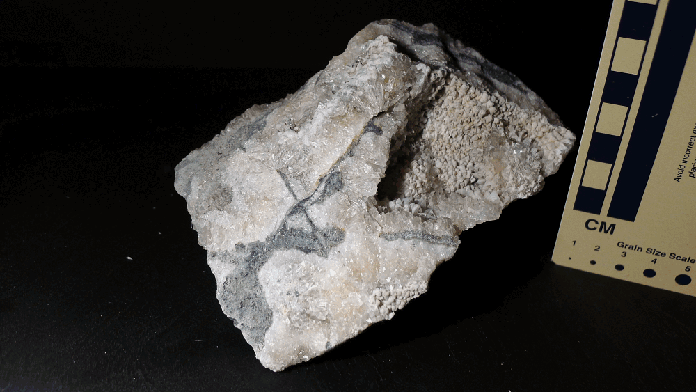 Limestone and calcite veins with green hyalite opal under white, shortwave, and longwave light; 13 cm