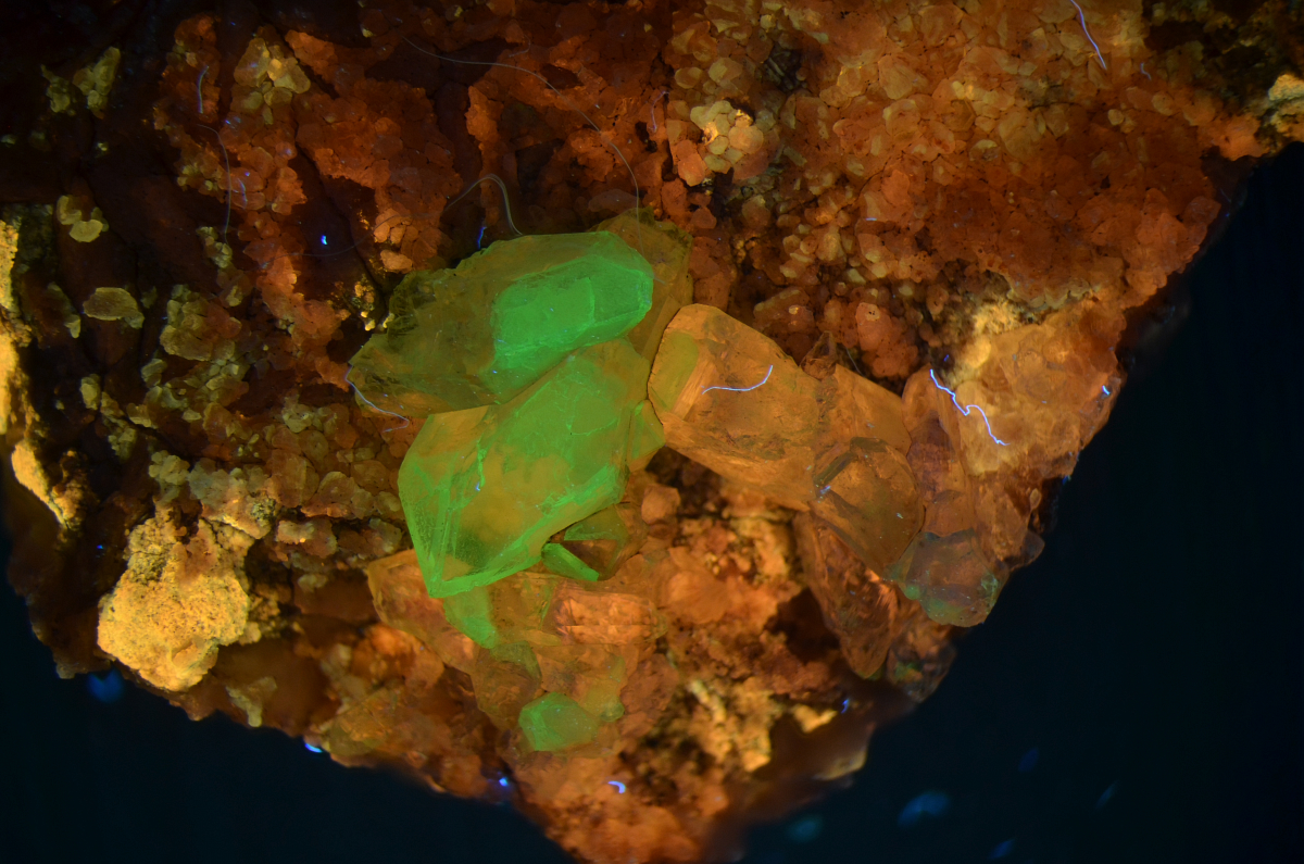 Green fluorescing quartz on clear quartz, yellow caliche on calcite; shortwave; field of view is 2.5 cm; stacked from 13 images