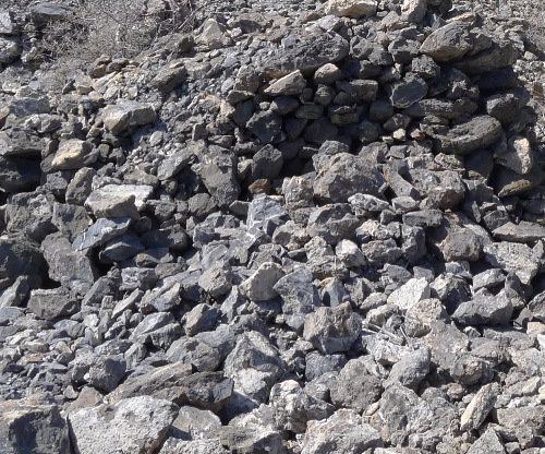 Mine dump in daylight, most of the rocks fluoresce